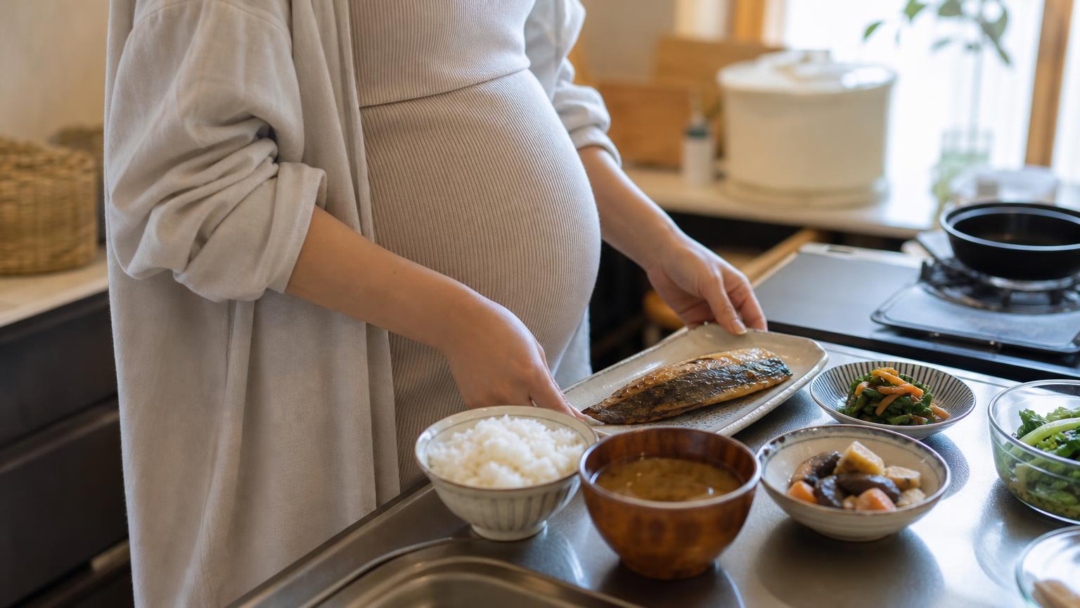 台所で簡単な和食の食事を用意する妊婦の手元とおなか(顔は写っていない)